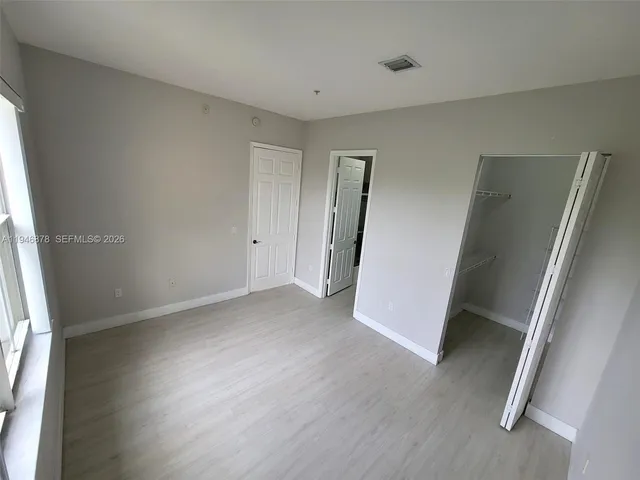 an empty room with wooden floor and entrance