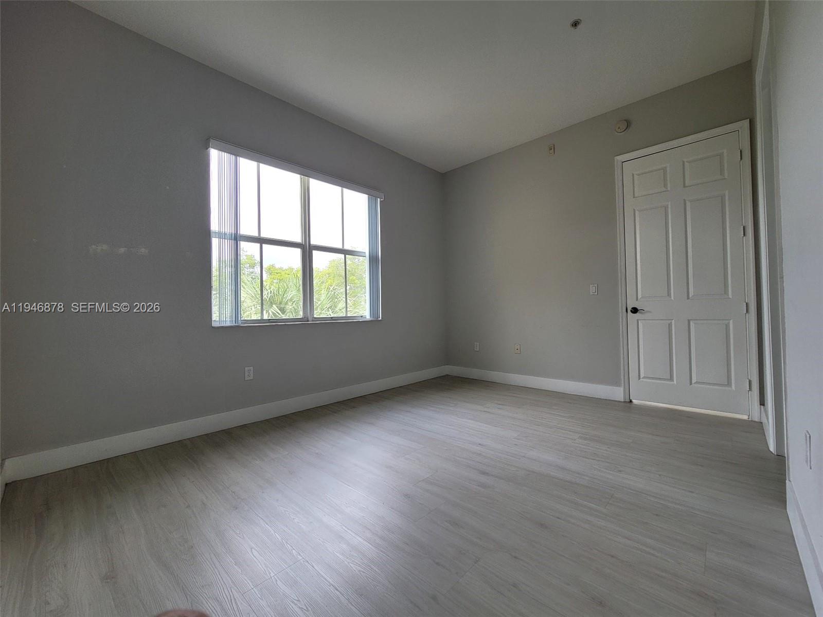 4602 Southwest 160th Avenue, Unit 536 Miramar, FL 33027 - Photo 15 of 30 an empty room with wooden floor and windows