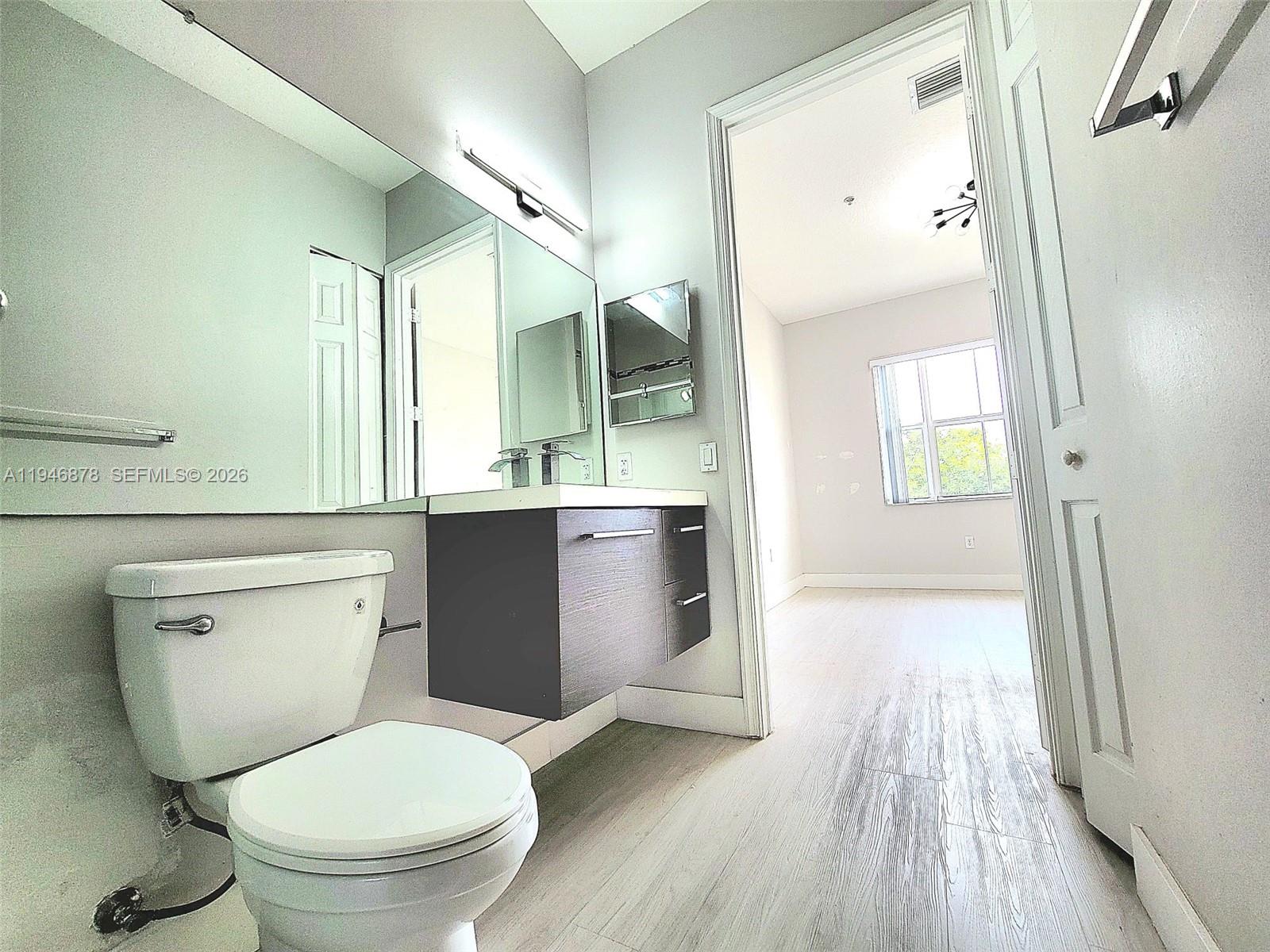 4602 Southwest 160th Avenue, Unit 536 Miramar, FL 33027 - Photo 19 of 30 a bathroom with a toilet sink and a mirror