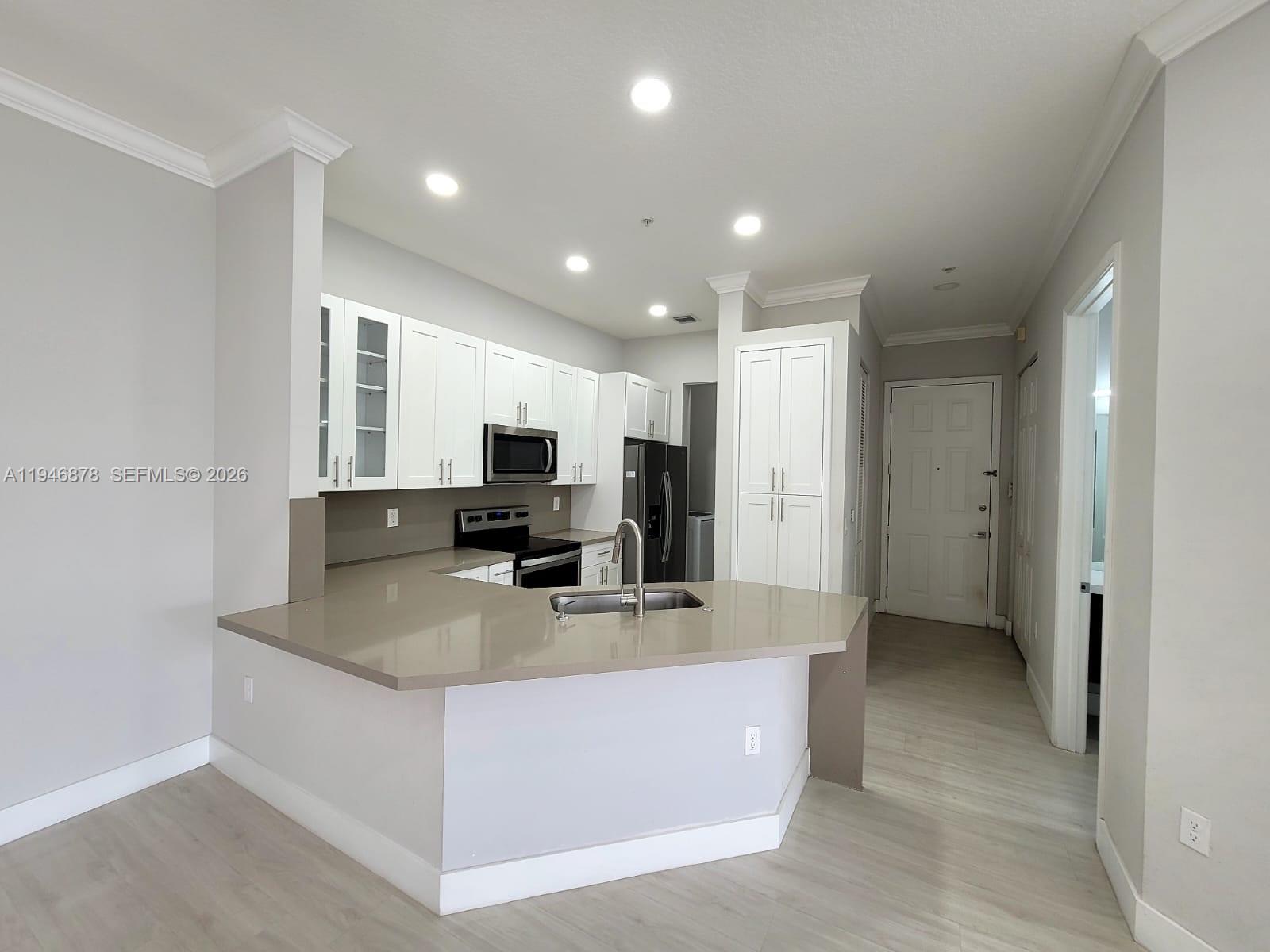 4602 Southwest 160th Avenue, Unit 536 Miramar, FL 33027 - Photo 2 of 30 a large kitchen with kitchen island a counter top stainless steel appliances and cabinets