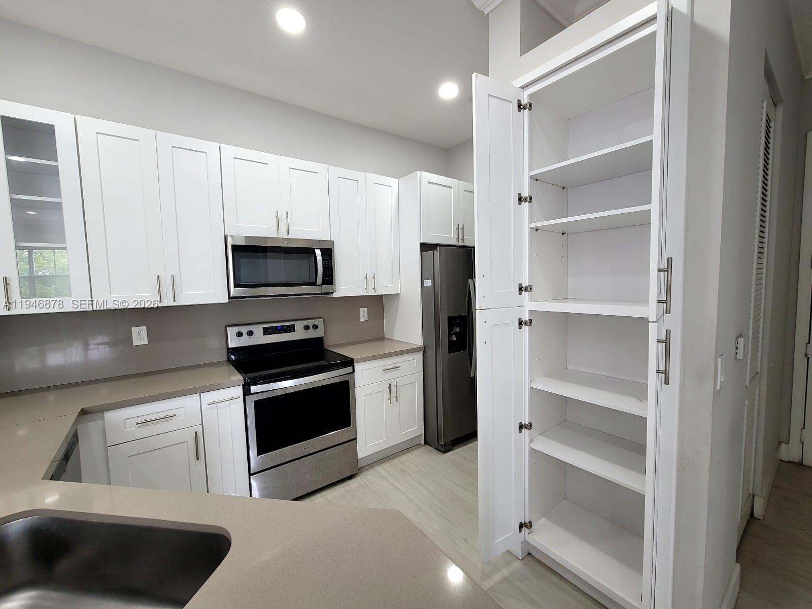 4602 Southwest 160th Avenue, Unit 536 Miramar, FL 33027 - Photo 4 of 30 a kitchen with white cabinets and stainless steel appliances