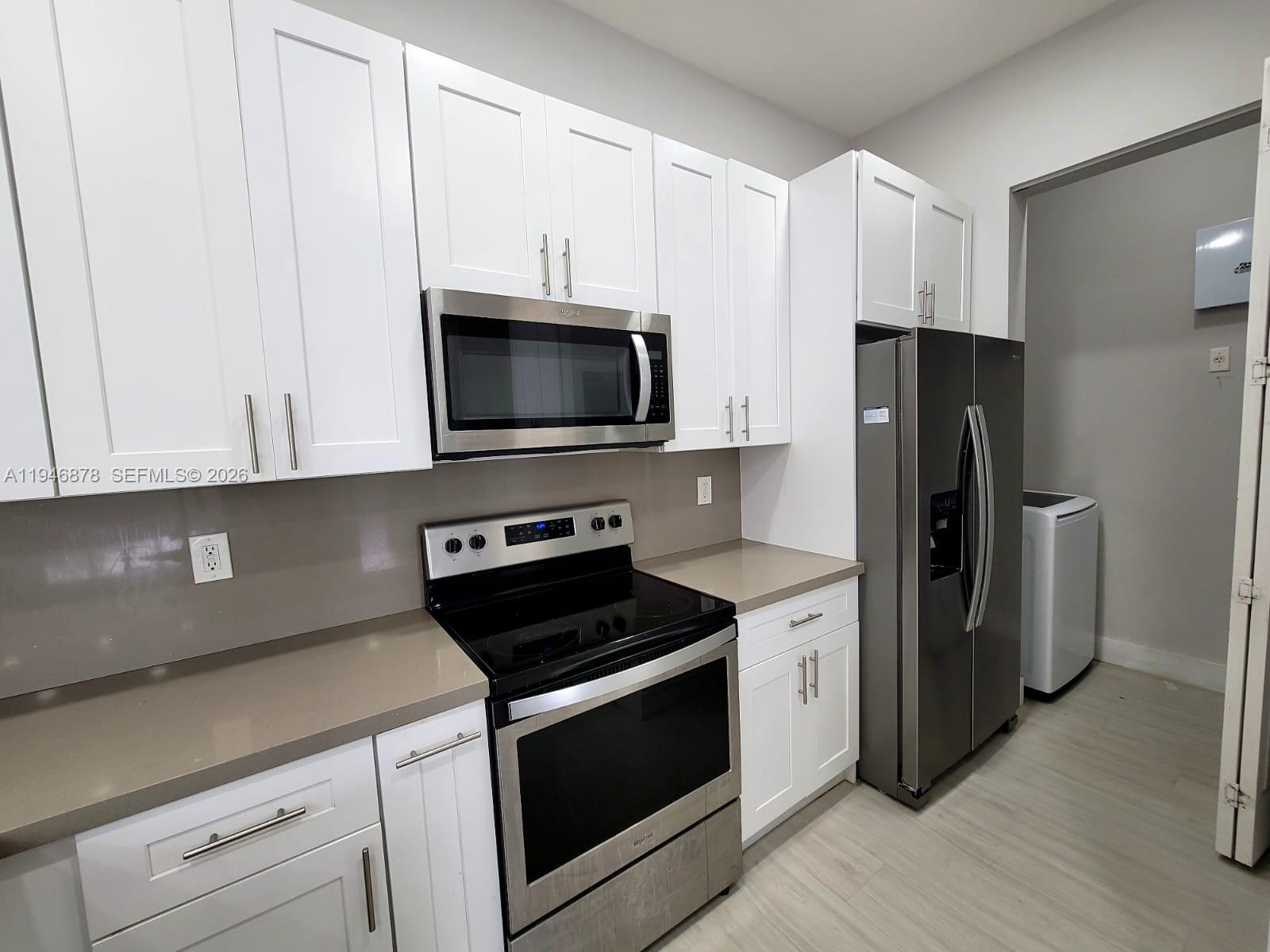 4602 Southwest 160th Avenue, Unit 536 Miramar, FL 33027 - Photo 5 of 30 a kitchen with a refrigerator stove and white cabinets
