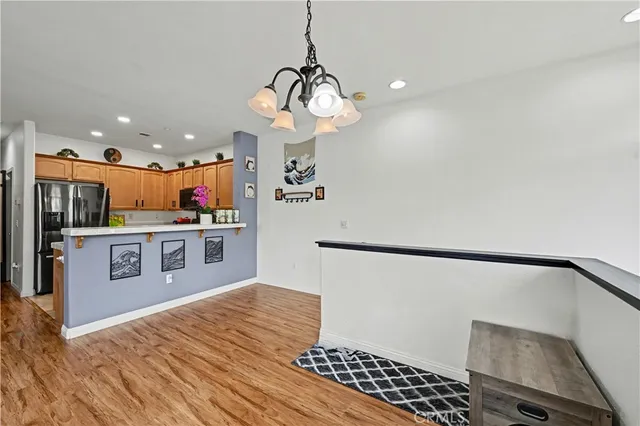 a kitchen with stainless steel appliances granite countertop a refrigerator a oven a sink and a wooden floors