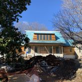 a front view of a house with a tree