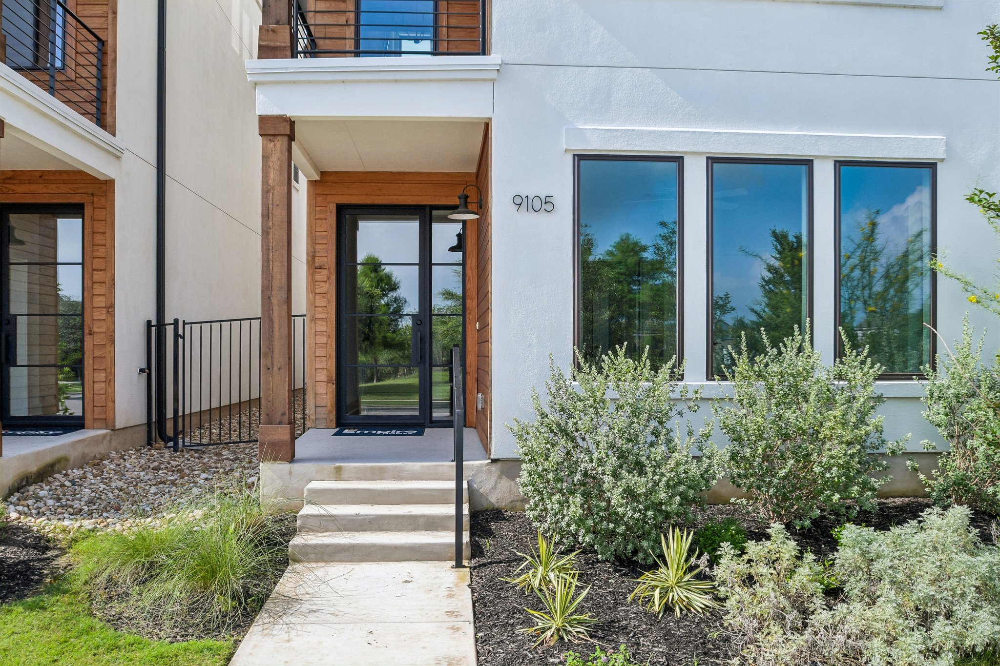9105 Cattle Baron Path Austin, TX 78747 - Photo 4 of 31 Modern facade with a sleek entryway and neatly landscaped garden beds.