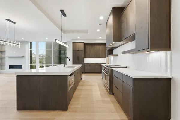 a large kitchen with stainless steel appliances a sink and a stove