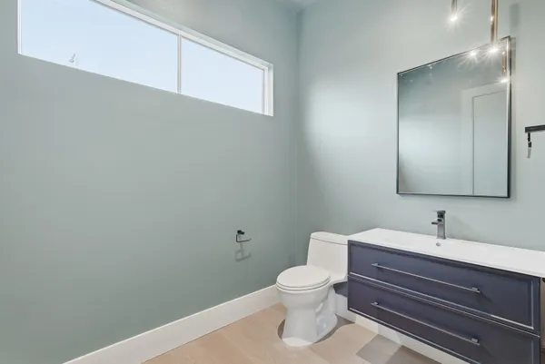 a bathroom with a sink a toilet and a mirror