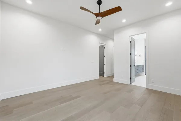 an empty room with ceiling fan and window