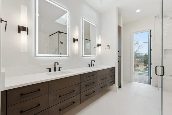 a spacious bathroom with double vanity sink a mirror and a shower