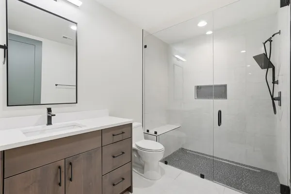 a bathroom with a sink a toilet and shower
