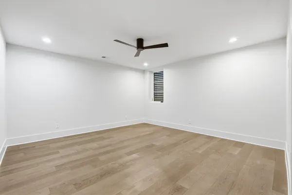 an empty room with a window and a ceiling fan