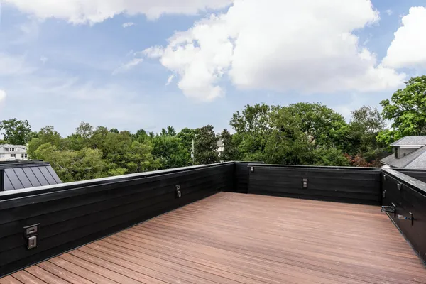 a view of a roof deck with wooden floor and city view