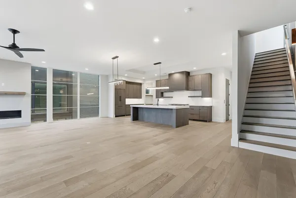 a view of kitchen with stainless steel appliances wooden floor and living room