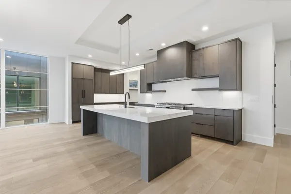 a large kitchen with kitchen island a sink stainless steel appliances and cabinets