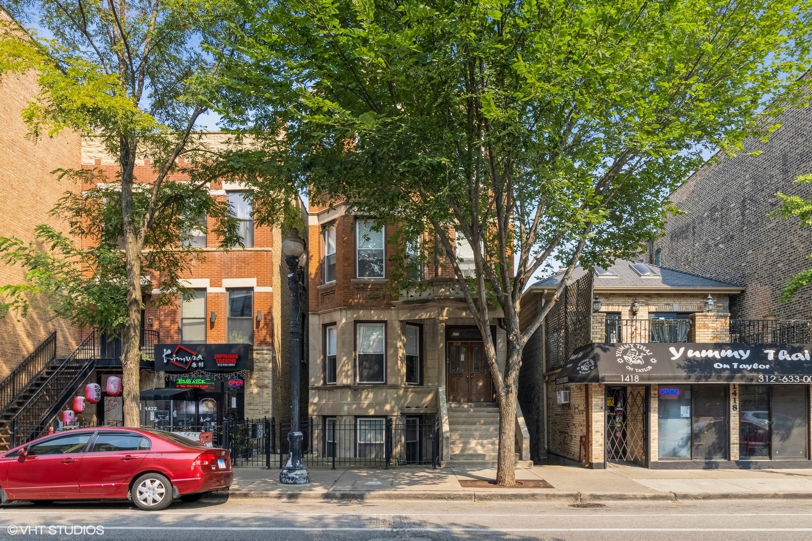 a front view of residential houses with yard and trees