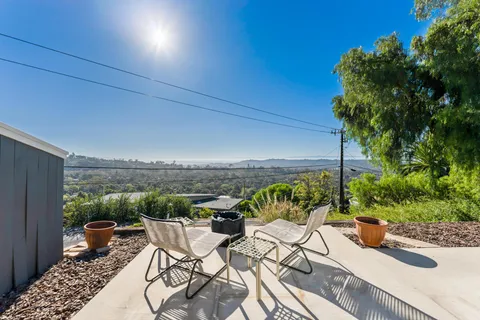 a view of a terrace with furniture and a garden