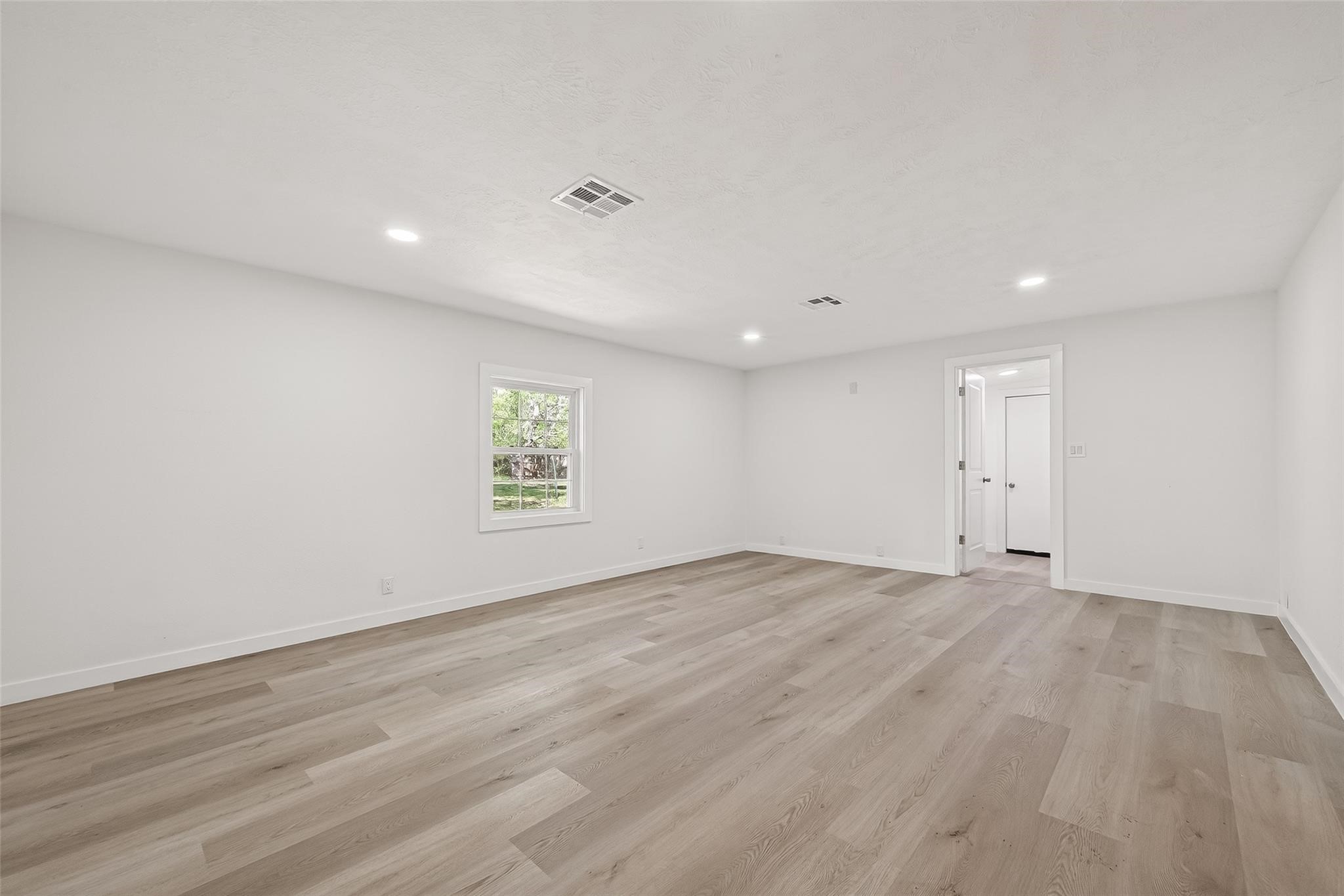 815 Brooks Avenue Rosenberg, TX 77471 - Photo 13 of 48 a view of an empty room with wooden floor and a window