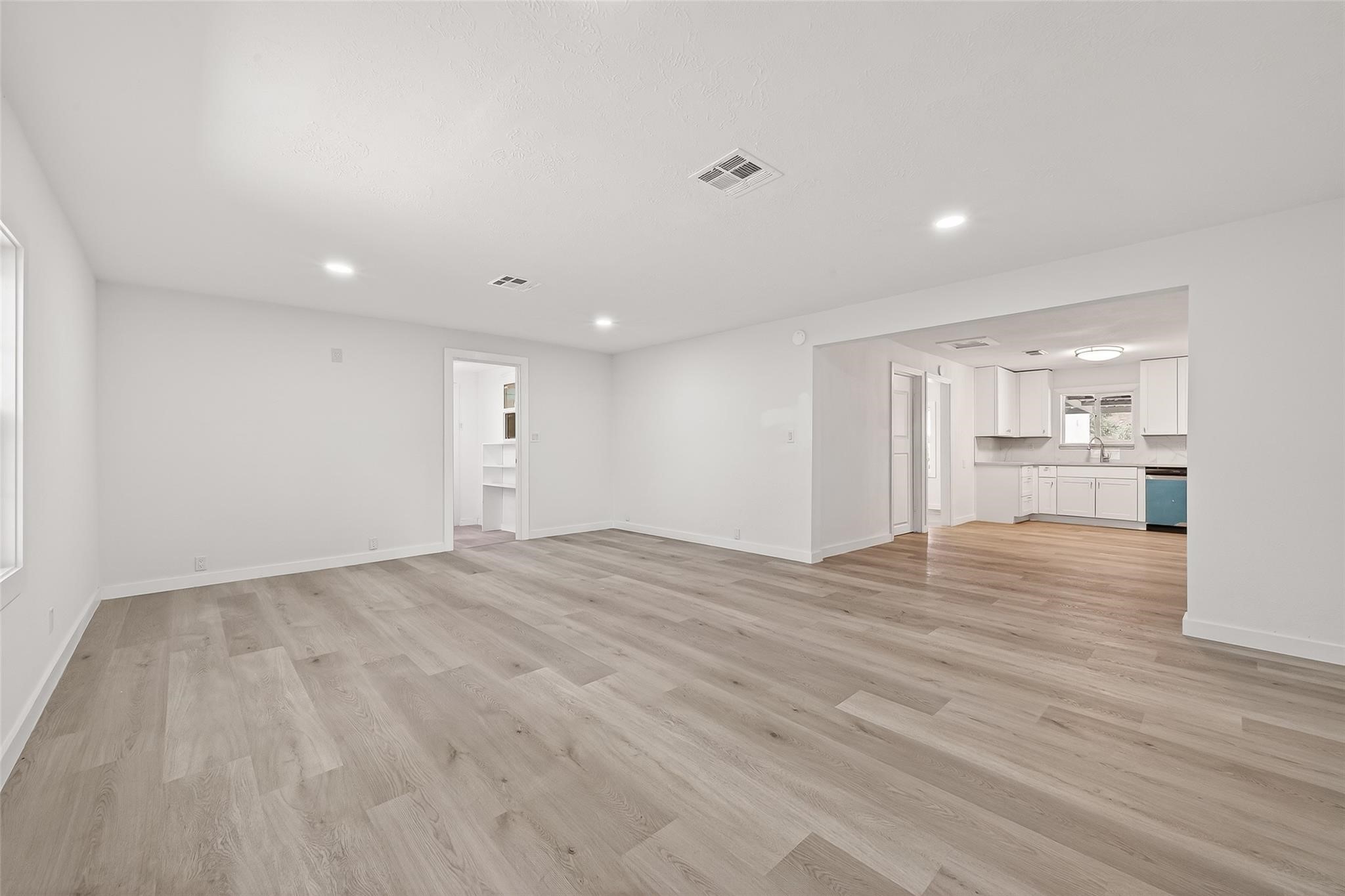 815 Brooks Avenue Rosenberg, TX 77471 - Photo 14 of 48 a view of empty room with wooden floor and kitchen