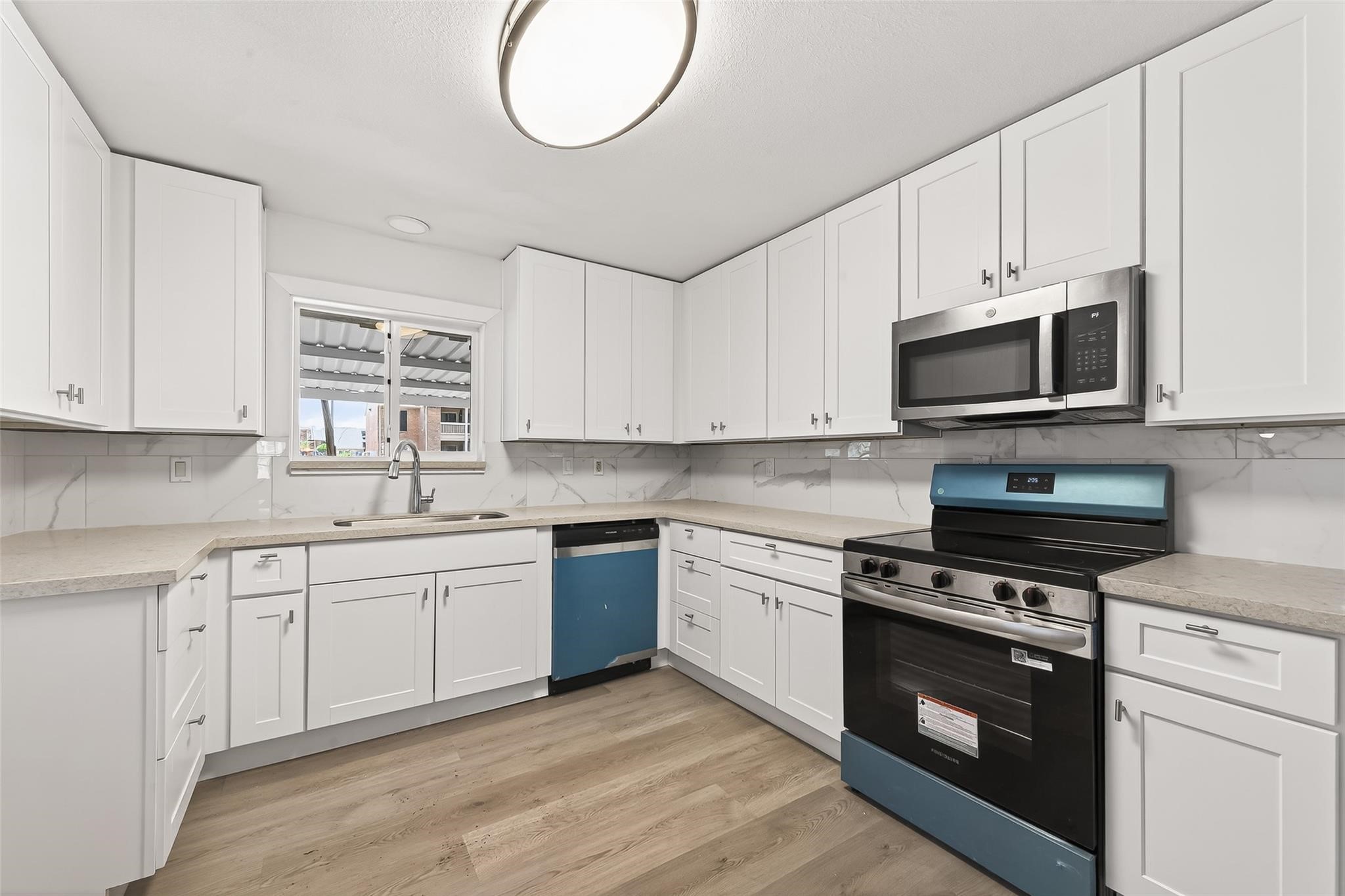 815 Brooks Avenue Rosenberg, TX 77471 - Photo 21 of 48 a kitchen with stainless steel appliances granite countertop a stove a sink and a microwave