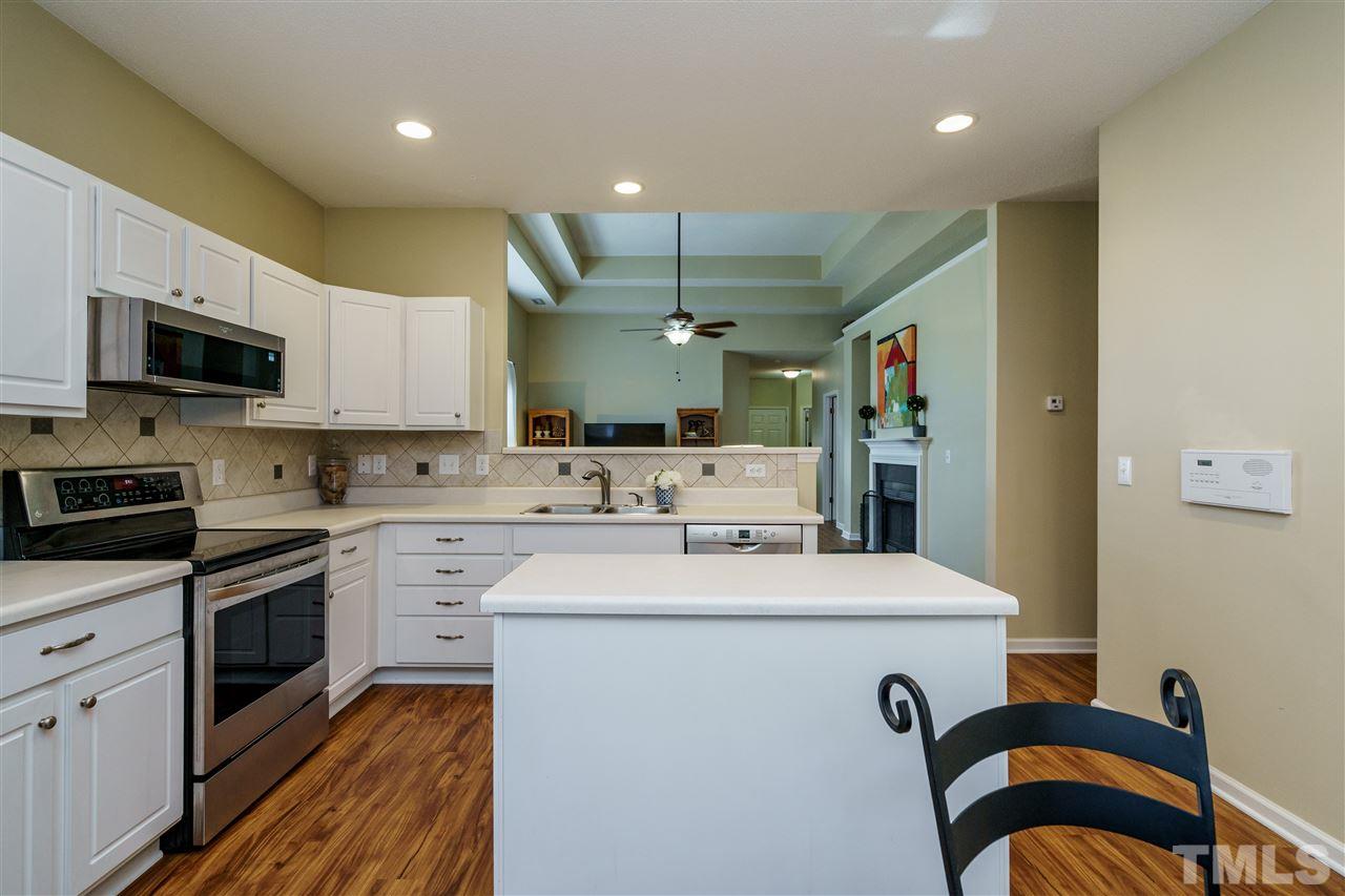 4848 Tommans Trail Raleigh, NC 27616 - Photo 11 of 22 a kitchen with a sink stainless steel appliances and white cabinets