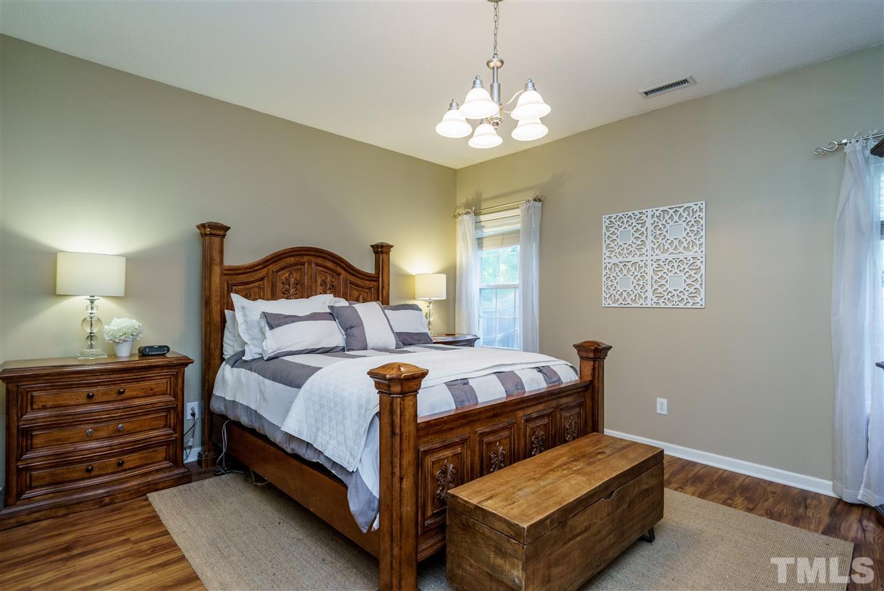 4848 Tommans Trail Raleigh, NC 27616 - Photo 14 of 22 a bedroom with a bed chandelier and a window