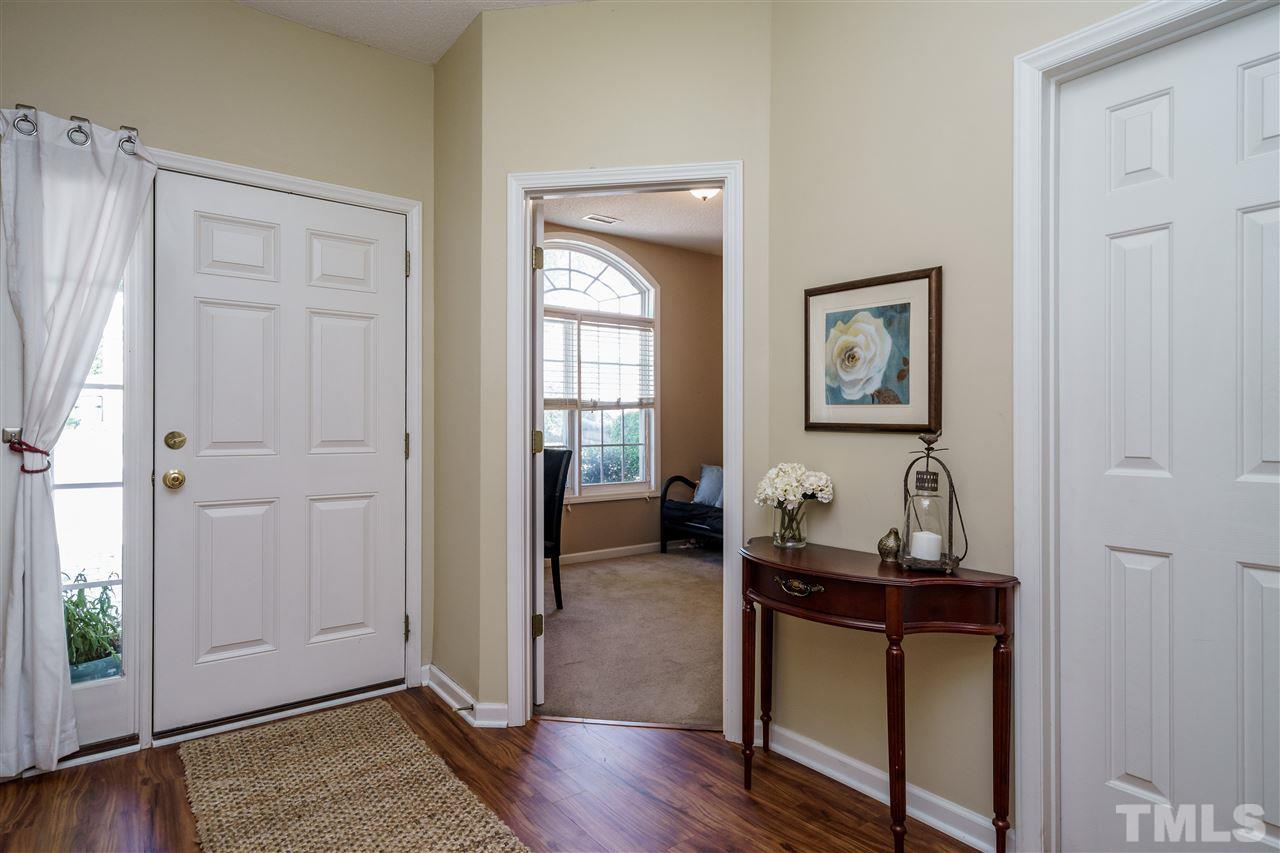 4848 Tommans Trail Raleigh, NC 27616 - Photo 4 of 22 a room that has a mirror and a wooden floor