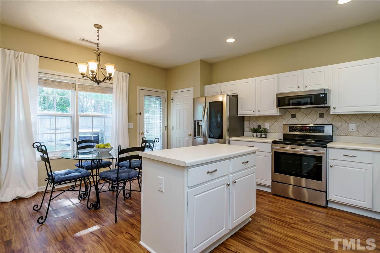 4848 Tommans Trail Raleigh, NC 27616 - Photo 10 of 22 a kitchen with kitchen island granite countertop a stove a sink a dining table and chairs