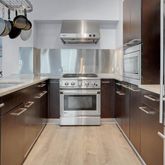 a kitchen with stainless steel appliances granite countertop a stove a sink and a refrigerator