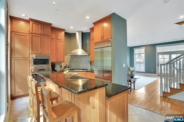 a kitchen with stainless steel appliances granite countertop a sink a stove and a refrigerator