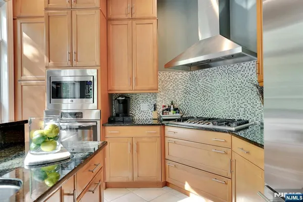 a kitchen with stainless steel appliances granite countertop a sink stove and cabinets