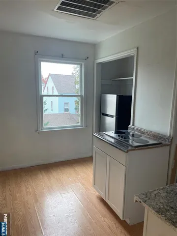 a kitchen with granite countertop a stove and a wooden floor
