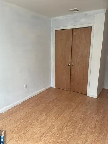 an empty room with wooden floor and sliding door