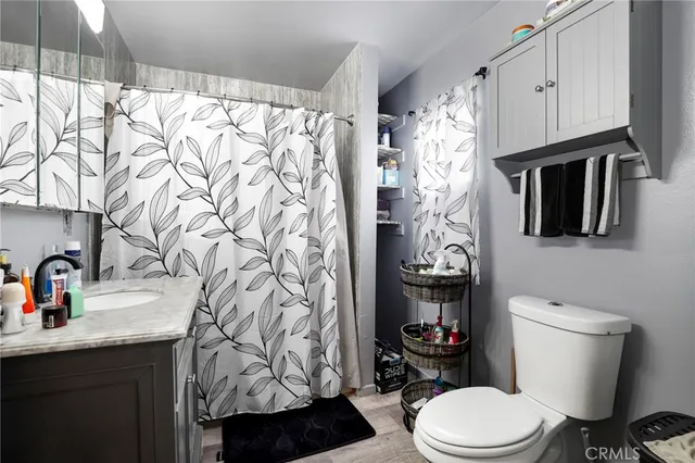 a bathroom with a toilet sink and shower curtain