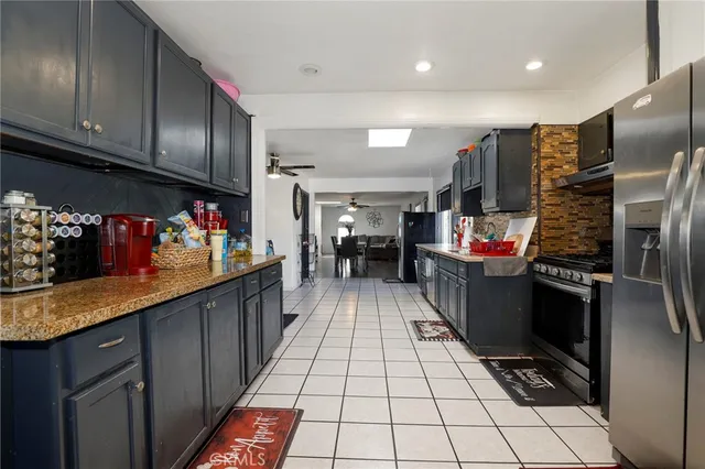 a kitchen with stainless steel appliances kitchen island granite countertop a refrigerator and a stove