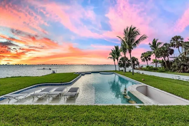 a view of a house with a swimming pool and a small yard
