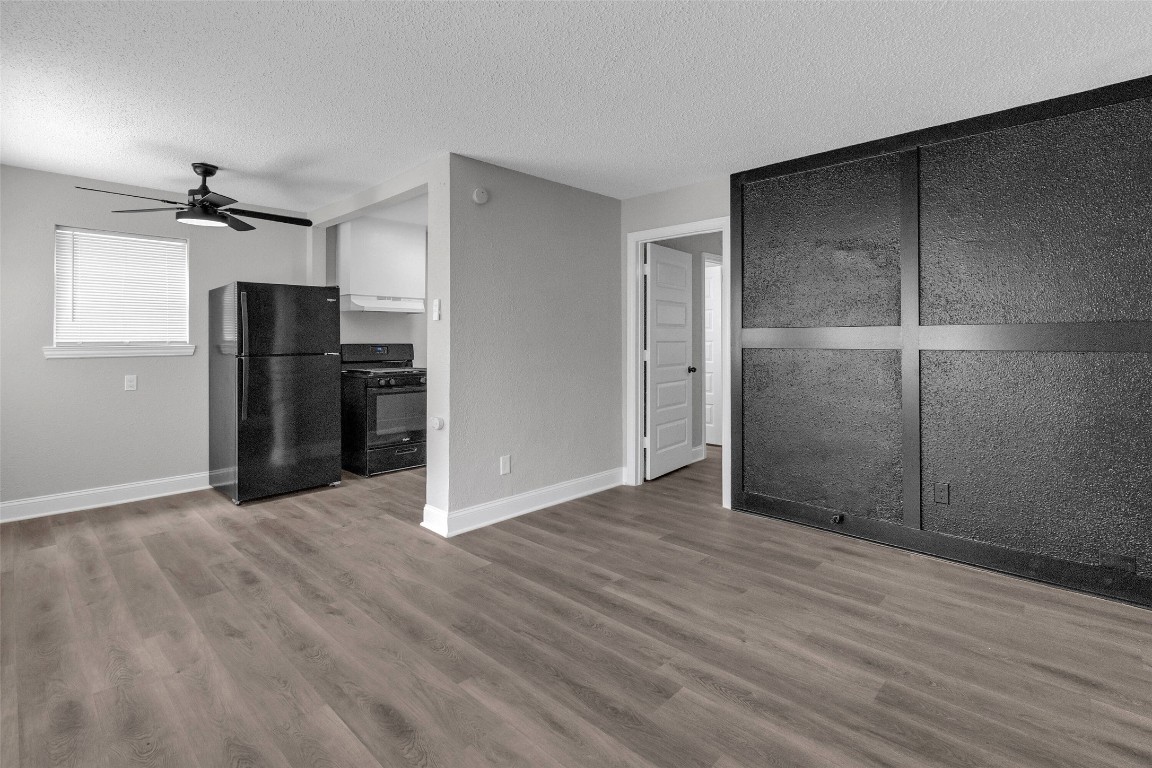 3613 Crane Street Houston, TX 77026 - Photo 18 of 23 a view of an empty room with wooden floor and a kitchen