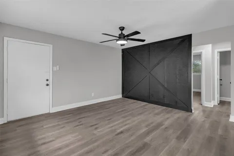a view of a livingroom with a ceiling fan and wooden floor