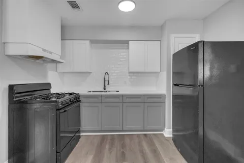 a kitchen with a refrigerator and a stove top oven
