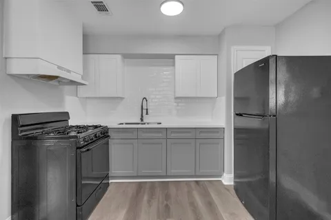 a kitchen with a refrigerator and a stove top oven