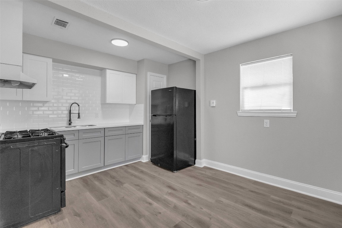 3613 Crane Street Houston, TX 77026 - Photo 8 of 23 a kitchen with a refrigerator and a stove top oven