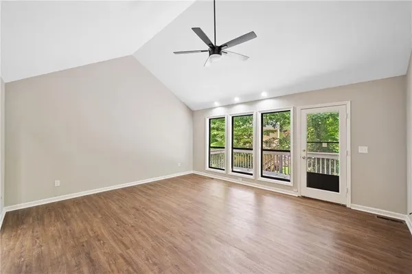 a view of a livingroom with wooden floor and a ceiling fan