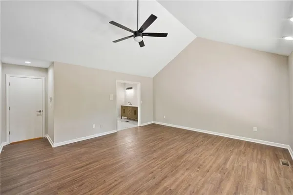 an empty room with wooden floor and a ceiling fan