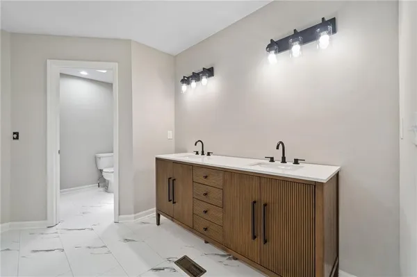 a spacious bathroom with a double vanity sink and a toilet