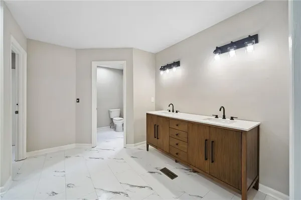 a spacious bathroom with a double vanity sink and mirror