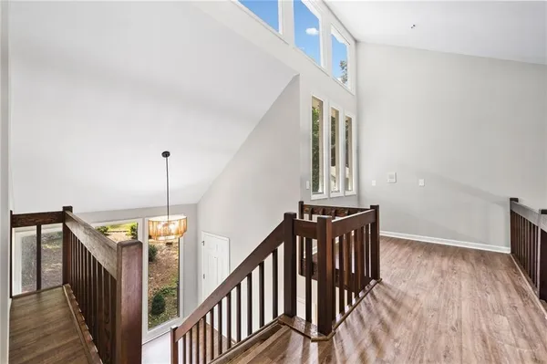 a view of a hallway with wooden floor and staircase