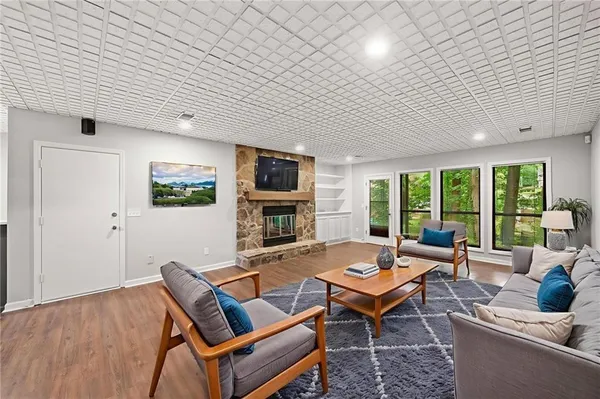 a living room with furniture a flat screen tv and a large window