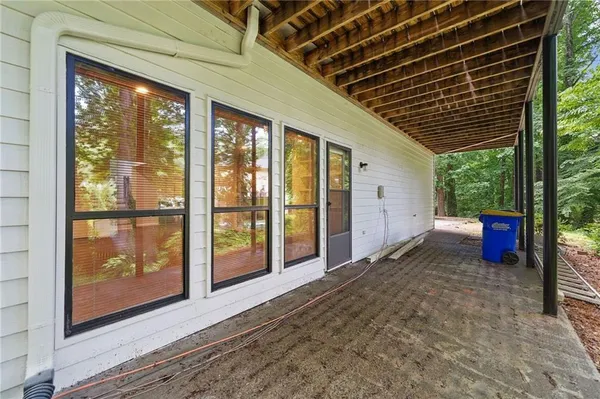 a view of a porch with wooden floor and floor to ceiling window