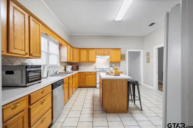 a kitchen with stainless steel appliances a stove top oven and a refrigerator