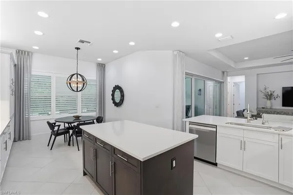 a kitchen with a sink a cabinets and chairs