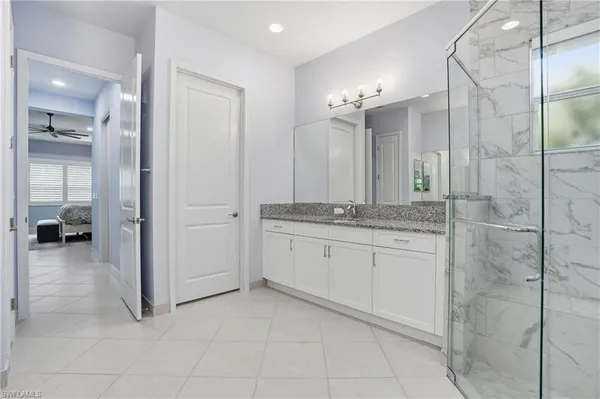 a bathroom with a granite countertop sink a mirror and a shower